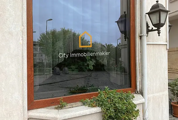 city immobilienmakler fenster mit logo