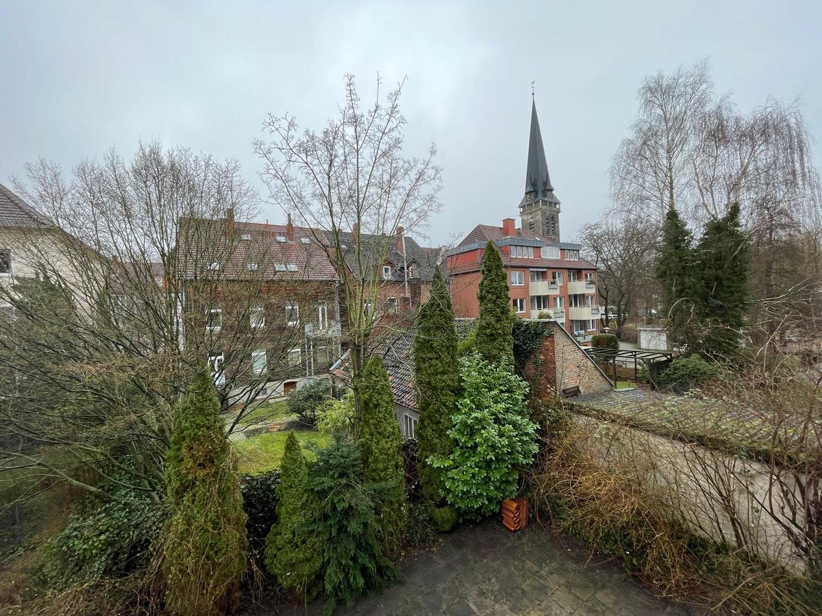 Blick ins Grüne mit Kirchturm aus einem Apartment in Hannover-Herrenhausen