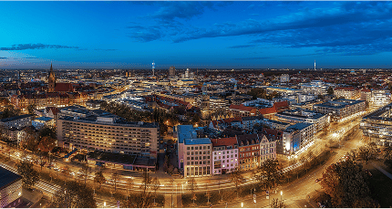 Stadtansicht bei Nacht mit beleuchteten Straßen und Hochhäusern aus der Vogelperspektive