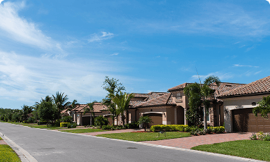 Straße in einer amerikanischen Wohnsiedlung mit Palmen und mediterranen Hausfassaden