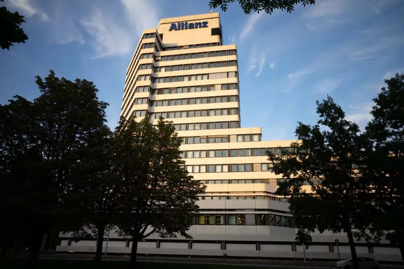 Hochhaus mit Allianz-Schriftzug hinter Bäumen