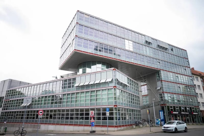 Modernes auskragendes Bürogebäude mit verspiegelter Fassade an einer Straßenecke